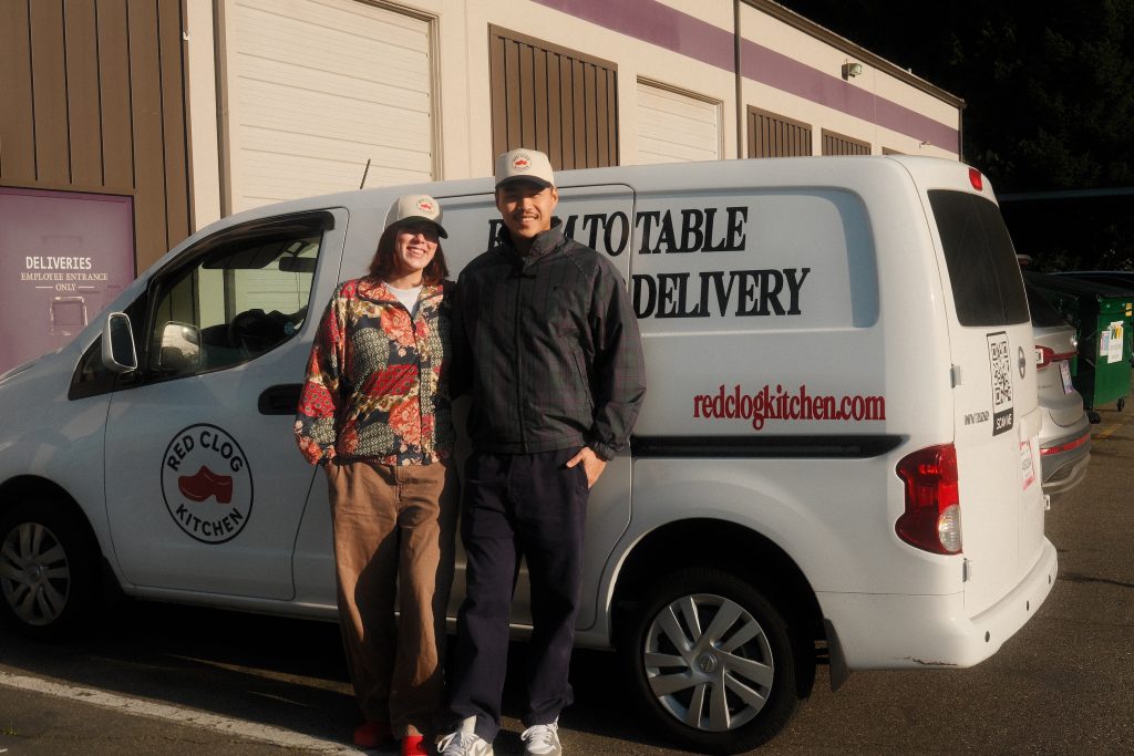 Red Clog Kitchen owners standing in front of their meal delivery van