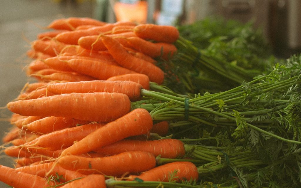a pile of fresh, local carrots from a farms stand